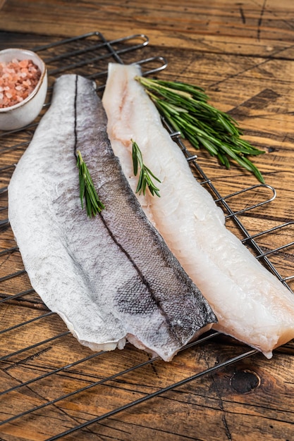 Filetti di pesce crudo alla griglia con rosmarino ed erbe aromatiche Fondo in legno Vista dall'alto