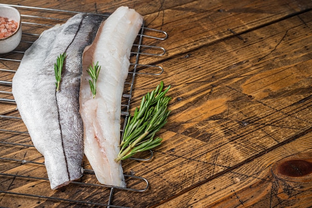 Filetti di pesce crudo alla griglia con rosmarino ed erbe aromatiche Sfondo in legno Vista dall'alto Spazio di copia