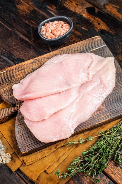 Filetti di petto di cotoletta di pollo crudo fresco su una tavola di legno carne di pollo Sfondo di legno Vista dall'alto