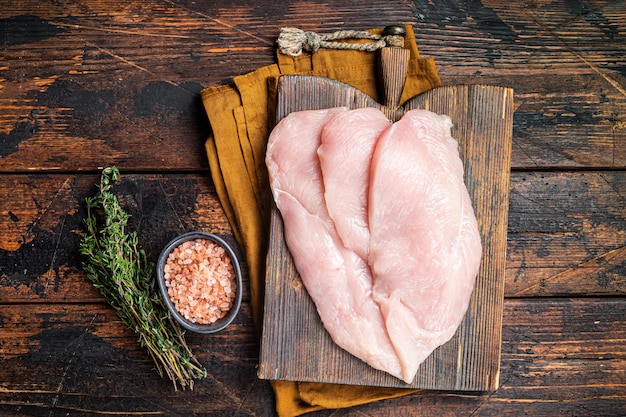 Filetti di petto di cotoletta di pollo crudo fresco su una tavola di legno carne di pollo Sfondo di legno Vista dall'alto