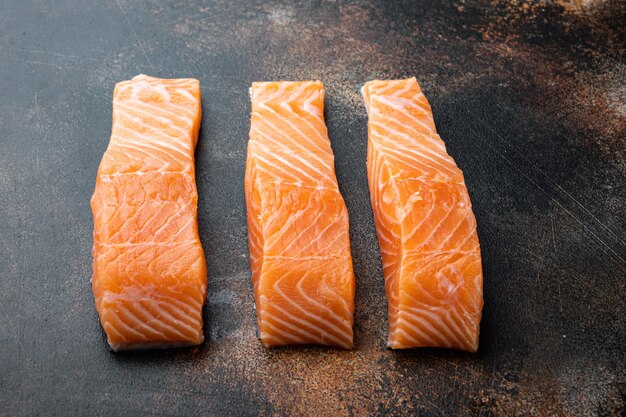 Filetti di salmone crudi sulla vecchia tavola di legno