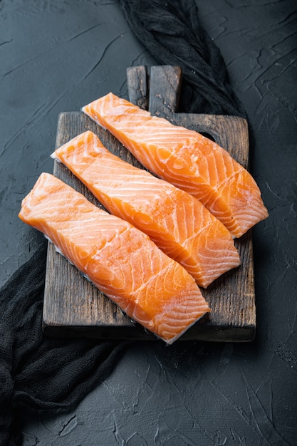 Filetti di salmone crudi sulla vecchia tavola di legno