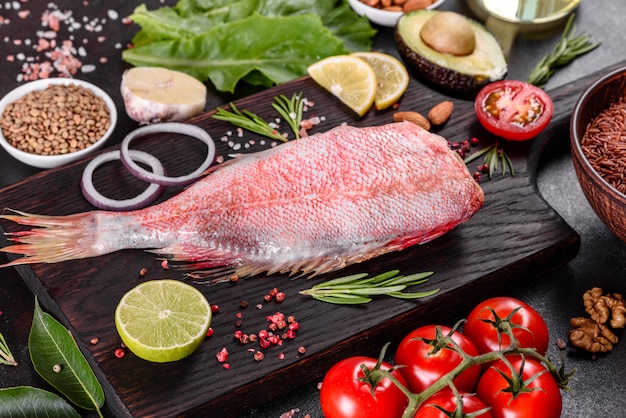 Filetto crudo di pesce persico del Mar Rosso preparato per la cottura con spezie ed erbe aromatiche