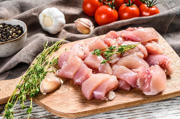 Filetto di carne di pollo crudo tagliato a cubetti sul tagliere. Vista dall'alto