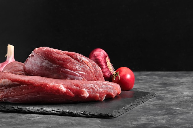 Filetto di filetto di manzo crudo su sfondo di marmo nero.