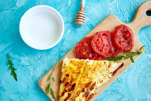 Filetto di luccio alla griglia con pomodori su tavola di legno