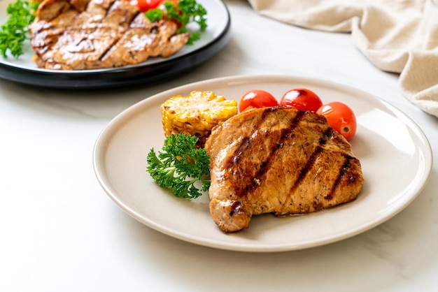 filetto di maiale alla griglia e barbecue con mais, carota e pomodori