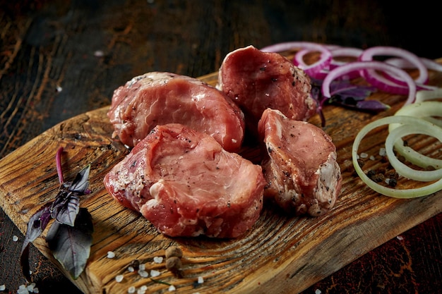 Filetto di maiale fresco marinato con spezie su una tavola di legno