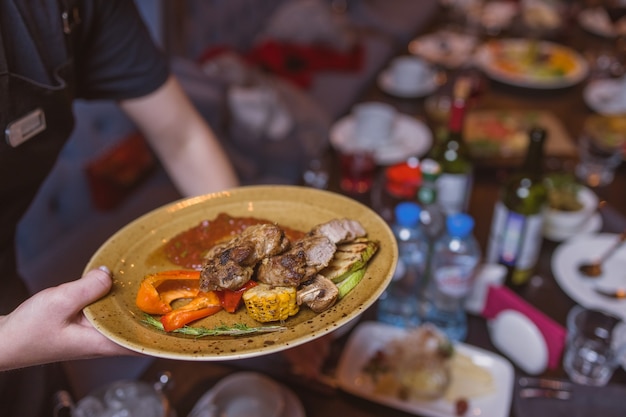 Filetto di manzo alla griglia e salsa di pepe su tagliere su fondo di legno scuro.