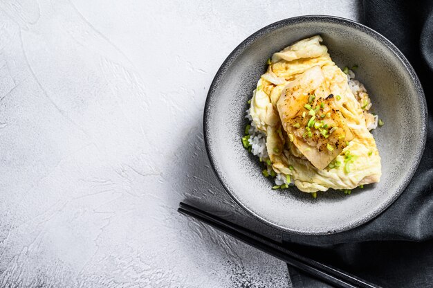 Filetto di merluzzo al vapore con frittata e riso. Sfondo bianco.