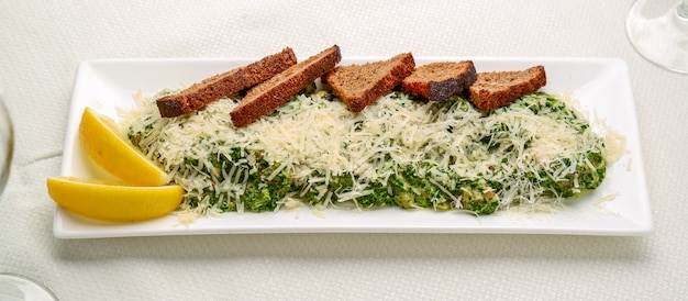 Filetto di pesce bianco con erbe su spinaci fritti
