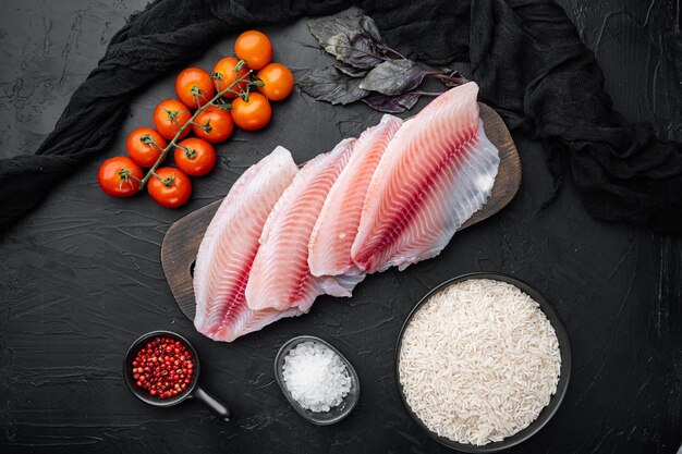 Filetto di pesce bianco, con ingredienti di riso basmati e pomodorini, su sfondo nero, vista dall'alto