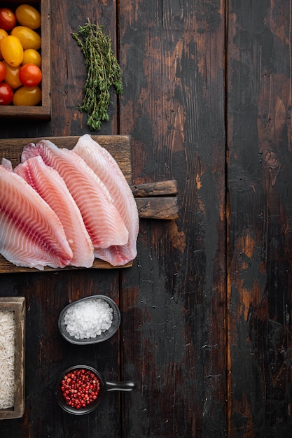 Filetto di pesce bianco, con riso basmati e pomodorini ingredienti, sul vecchio tavolo in legno, vista dall'alto con copia spazio per il testo