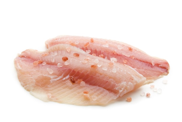Filetto di pesce bianco crudo preparato cosparso di sale rosa isolato su sfondo bianco