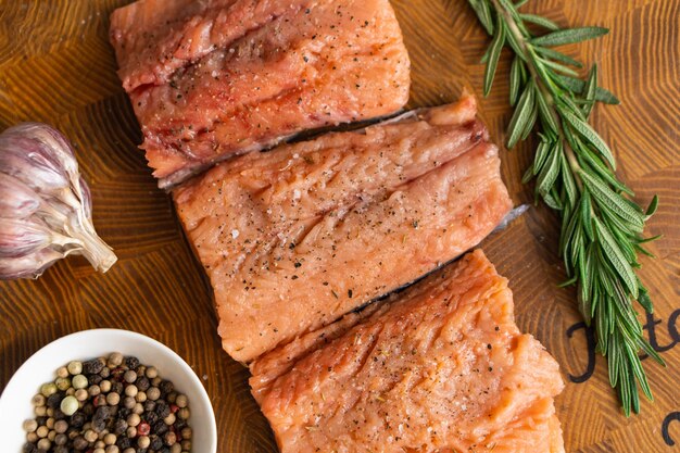 Filetto di pesce rosso al rosmarino per bistecche sul tagliere accanto al barattolo con spezie Vista dall'alto