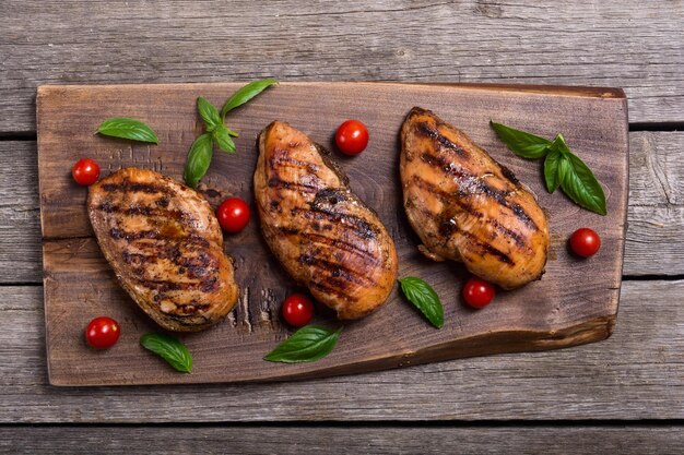 Filetto di petto di pollo alla griglia con basilico e pomodori Sfondo barbecue