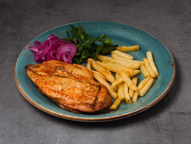 Filetto di pollo alla griglia con patate fritte cipolla rossa ed erbe aromatiche