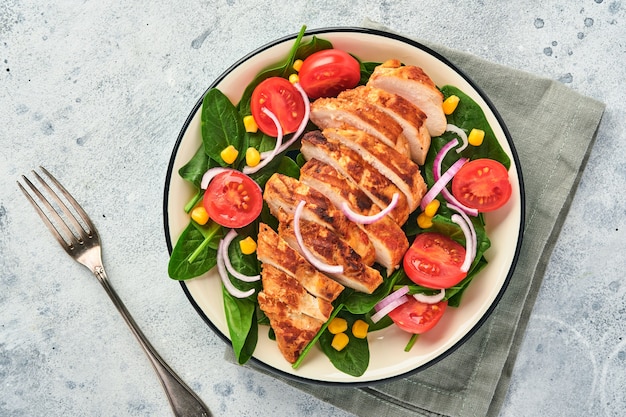 Filetto di pollo con insalata di spinaci, pomodorini, fiordaliso e cipolla