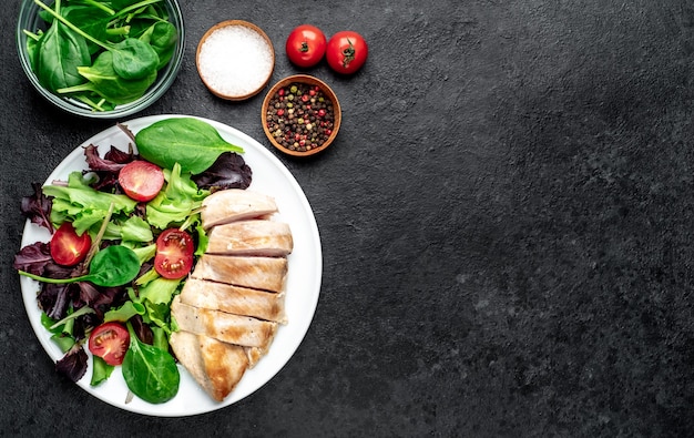 Filetto di pollo con insalata e spinaci Cibo sano sul tavolo di pietra