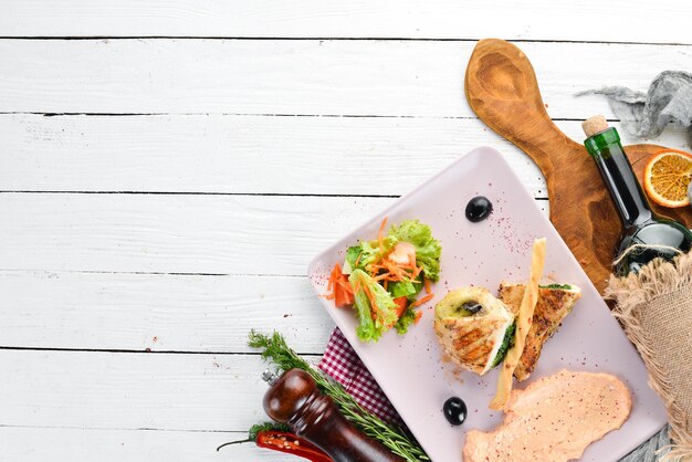 Filetto di pollo con spinaci, formaggio e funghi Su uno sfondo di legno Vista dall'alto Spazio libero per il testo