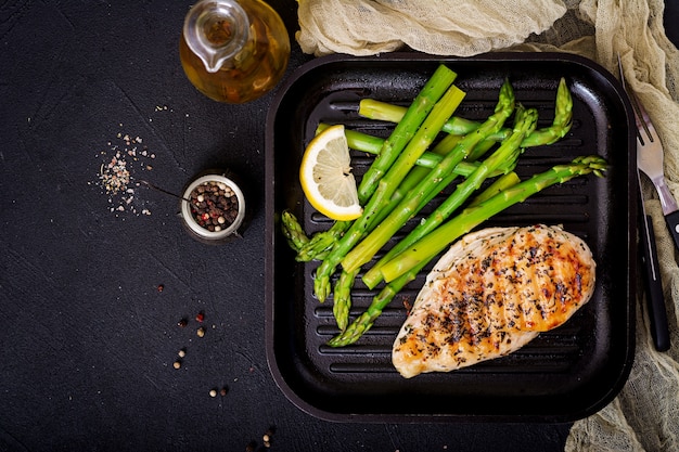 Filetto di pollo cotto su una griglia e contorno di asparagi.