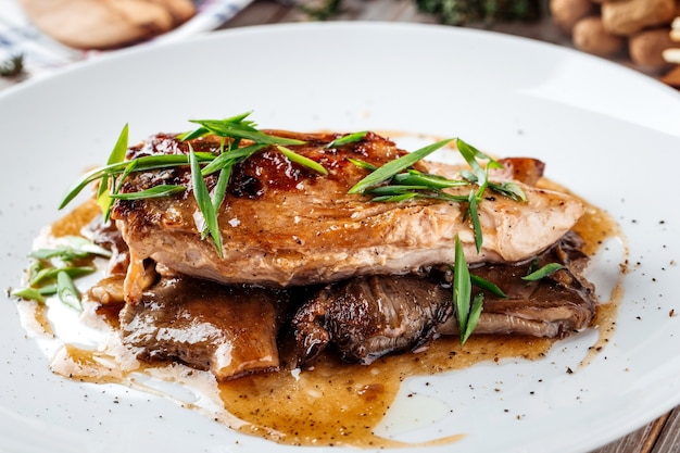 Filetto di pollo cotto sui funghi sul tavolo di legno