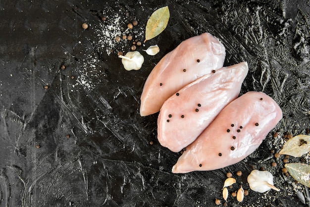 Filetto di pollo crudo isolato sul nero