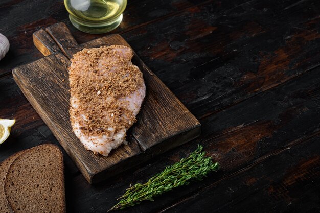 Filetto di pollo crumbet crudo con ingrediente, sulla tavola di legno