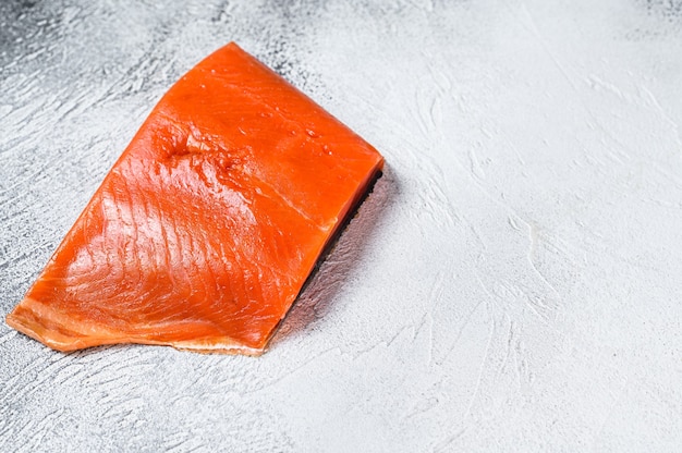 Filetto di salmone affumicato su un tavolo di legno.