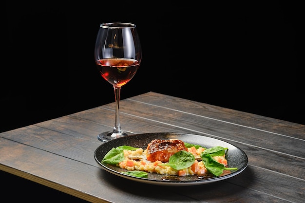 Filetto di salmone arrosto con bulgur con bicchiere di vino rosato su un tavolo