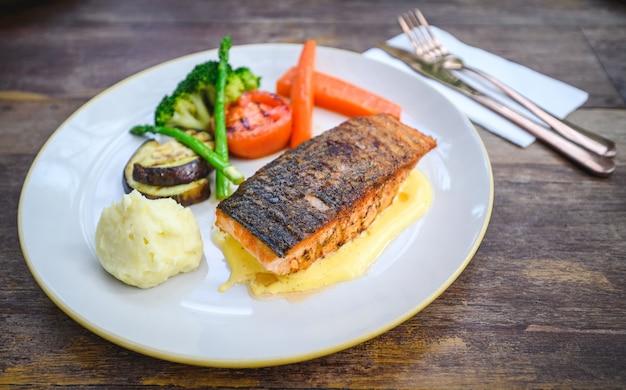 Filetto di salmone con salsa olandese sul piatto bianco