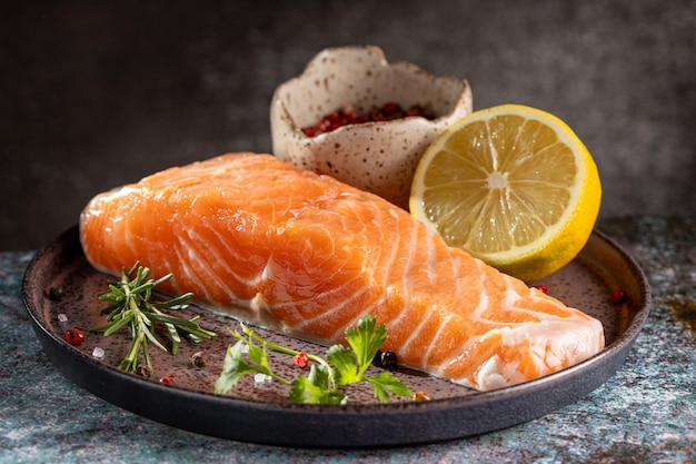 Filetto di salmone crudo fresco con ingredienti per la preparazione