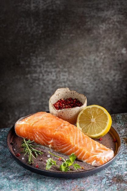Filetto di salmone crudo fresco con ingredienti per la preparazione