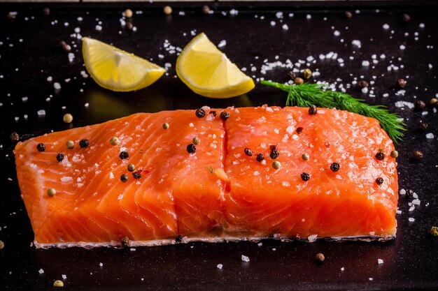 Filetto di salmone fresco con pepe di limone e sale marino su fondo scuro