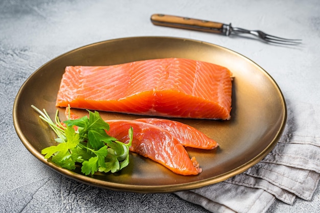 Filetto di salmone salato con timo in una piastra d'acciaio Sfondo bianco Vista dall'alto