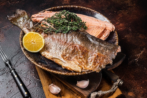 Filetto di trota arrosto di pesce alla griglia su un piatto con timo e limone Sfondo scuro Vista dall'alto