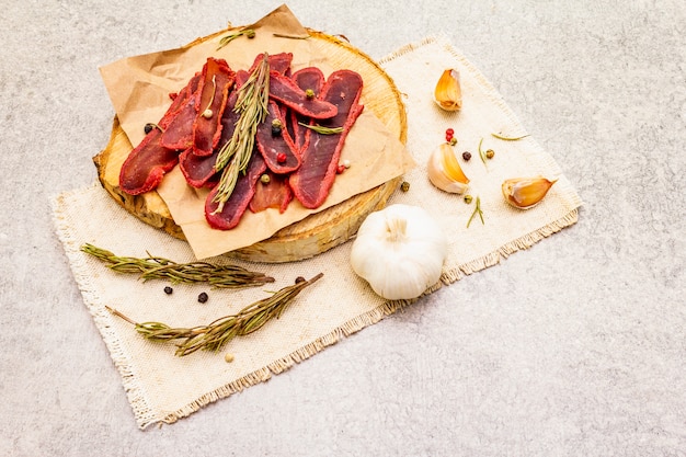 Filetto secco di carne di manzo con mix secco di pepe e rosmarino, peperoncino e aglio su un panno di lino vintage