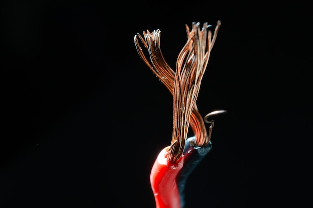 Fili di rame nudi in nero e rosso su sfondo scuro. macro.