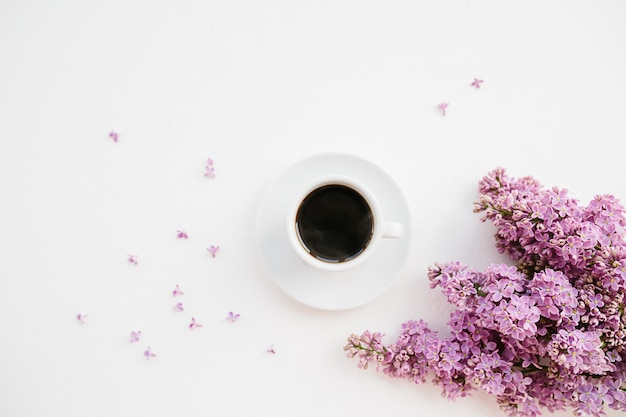 Filiale della tazza di caffè e del lillà su bianco