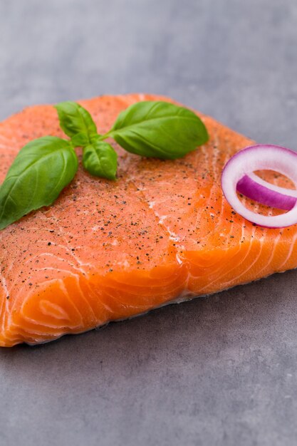 Fille di salmone fresco con spezie sul grigio.