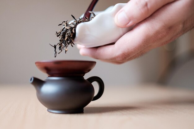 Filling a brown teapot through a funnel
