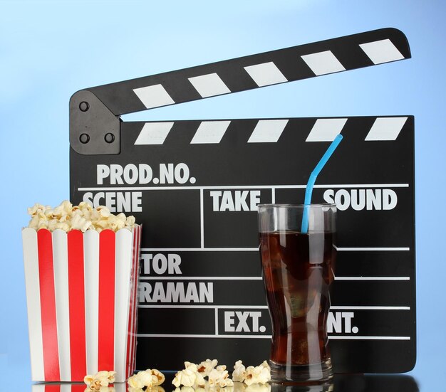 Film ciak cola e popcorn su sfondo blu