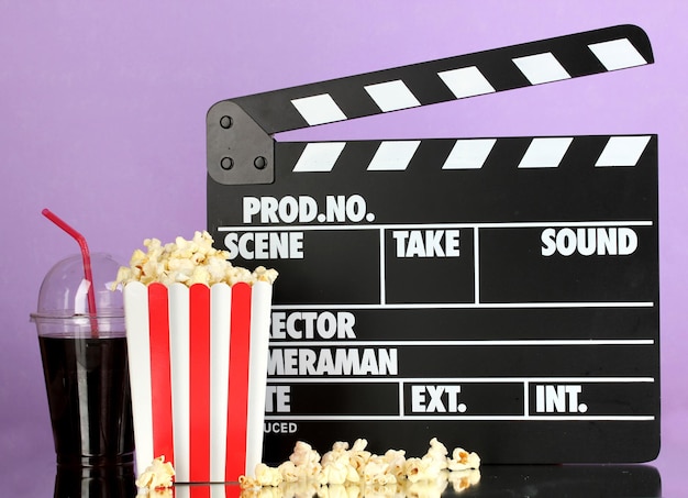 Film ciak cola e popcorn su sfondo viola