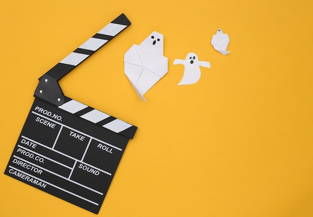 Film Ciak e fantasmi di carta su sfondo giallo. Film dell'orrore di Halloween. Vista dall'alto
