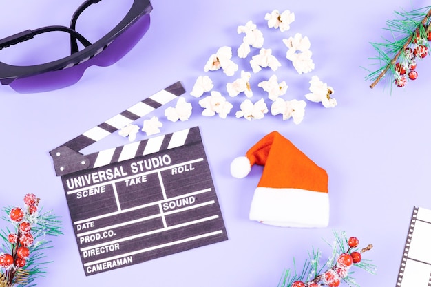 Film ciak popcorn occhiali pellicola striscia cappello di Babbo Natale e rami di abete