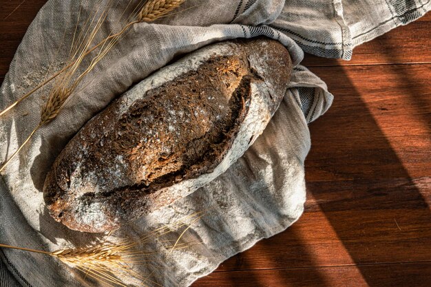 Filone di pane su tavola di legno e tasselli che evocano l'essenza del pane artigianale e naturale