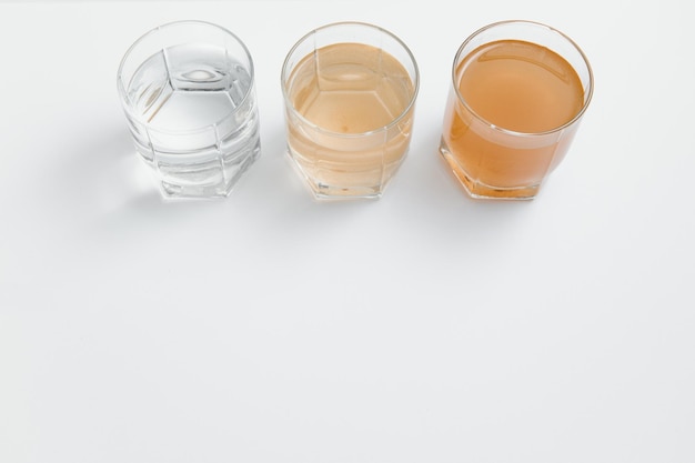 Filtri per l'acqua Concetto di tre bicchieri su sfondo bianco Sistema di filtrazione domestico