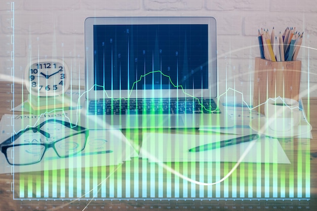 financial chart drawing and table with computer on background multi exposure concept of international markets
