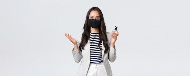 Finanza aziendale e occupazione covid19 prevenzione virus e concetto di allontanamento sociale Impiegata asiatica d'affari con maschera facciale che chiede di utilizzare un disinfettante per le mani che si prende cura dell'igiene