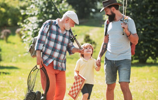 Fine settimana estivo felice nonno padre e nipote con canne da pesca pescatori uomini giorno di pesca